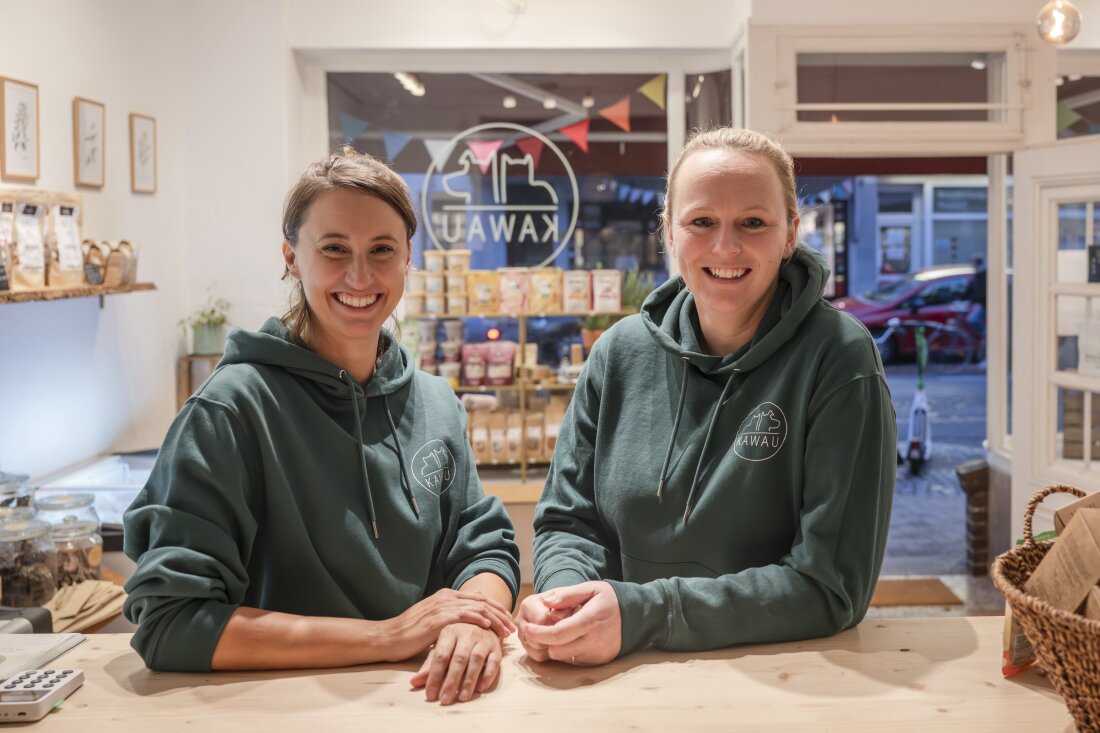 Zwei Frauen lächelnd, stehen im Laden von KAWAU Zwei Frauen lächelnd, stehen im Laden von KAWAU
